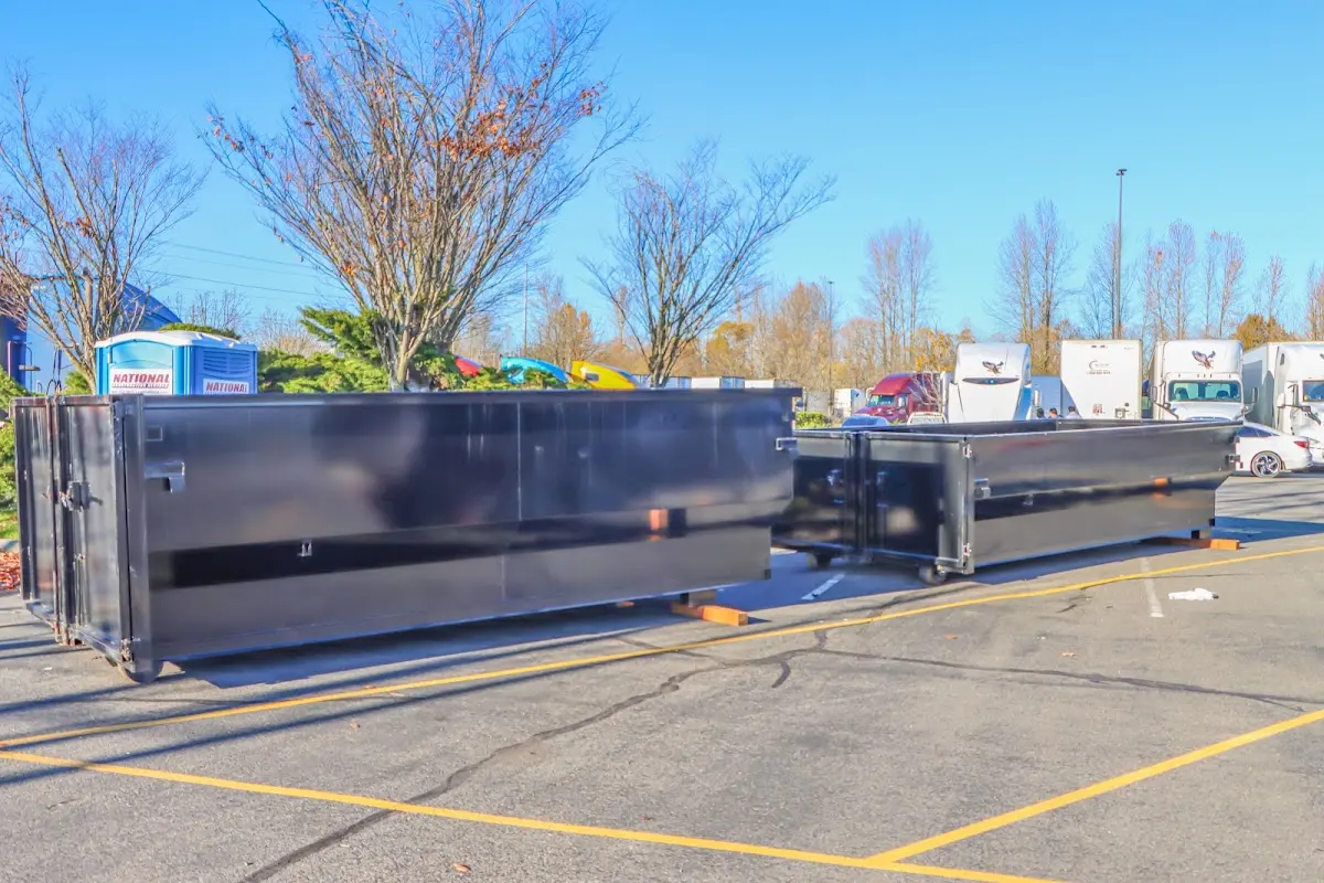 Professional dumpster rental service with roll-off container on residential driveway in Athol